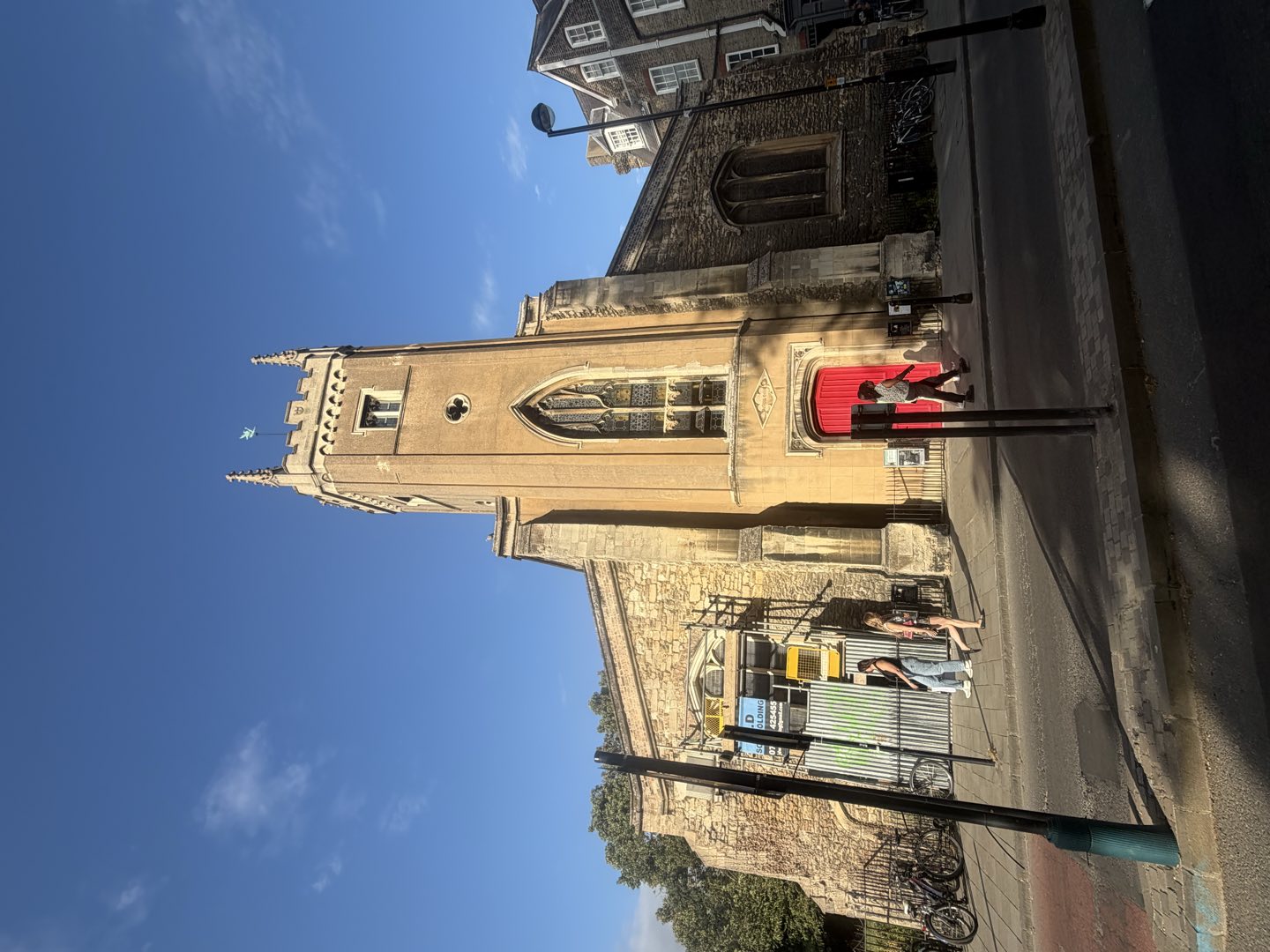 A stone church with a crenellated tower and a red door